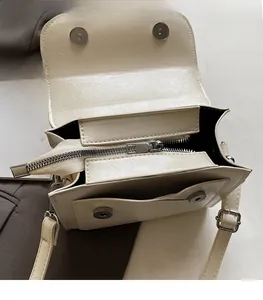 Détail du sac bandoulière en cuir PU blanc crème avec fermeture éclair en métal et fermoir aimanté