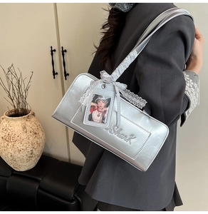 Dettaglio della borsa metallizzata argento con ricamo Shark e ciondolo con pizzo