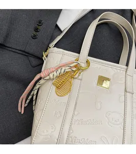 Detailed macro view of cute embossed bear and rabbit patterns on a creamy white tote bag
