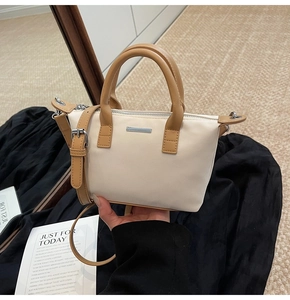 Detail of canvas bucket bag with brown faux leather handles and silver metal hardware