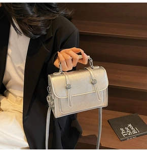 Gros plan du sac bandoulière argenté avec texture froissée et boucles métalliques