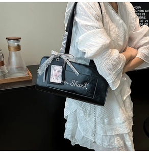 Dettaglio borsa nera in pelle PU con fiocco di pizzo bianco e decorazione a catena in metallo