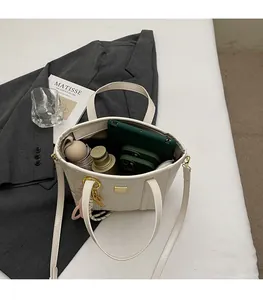 Spacious bucket bag interior holding a tablet, phone, water bottle, and umbrella