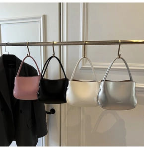 Detailansicht von vier glänzenden Leder-Eimertaschen in verschiedenen Farben