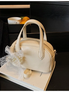 Sac à main blanc crème élégant avec nœud en dentelle et pendentif cœur en perles sur livre