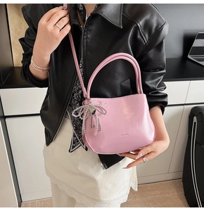 Detail der rosa Lackleder-Beuteltasche mit silberner Schleife und Perlenanhänger