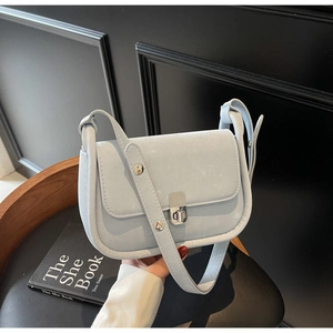Detail of light blue crossbody bag featuring silver twist lock and metallic studs