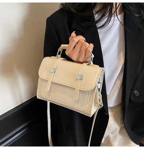 Gros plan d'un sac bandoulière en similicuir crème avec boucles argentées de luxe