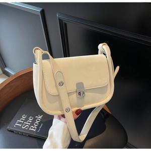 Detail of cream flap shoulder bag with silver metallic twist lock and textured finish
