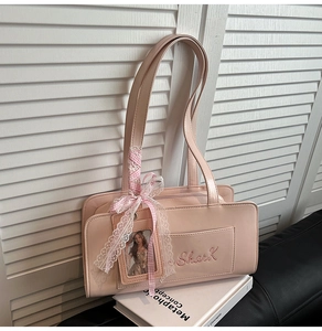 Dettaglio borsa rosa con nastro di pizzo, fiocco e ricamo Shark in stile Y2K
