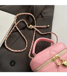 Dettaglio borsa a secchiello rosa trapuntata con cuore e catena dorata regolabile