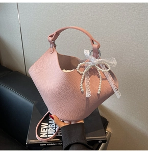 Borsa a secchiello rosa con trama litchi, fiocco di perle e nastro di pizzo