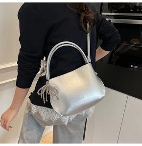Schicke silberne Spiegel-Beuteltasche mit Metallic-Schleife in moderner Küchenumgebung