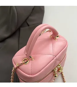 Dettaglio mini borsa a secchiello rosa trapuntata con ciondoli a cuore dorati