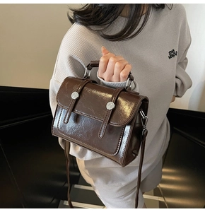 Détails du sac bandoulière marron foncé brillant avec boucles et poignée en cuir
