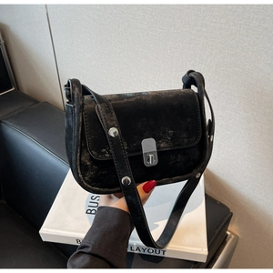 Detail of black metallic vintage crossbody bag with silver twist lock and rivet strap