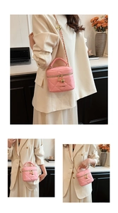 Détail du sac seau rose matelassé avec bandoulière chaîne et breloques cœur dorées