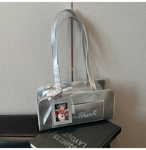 Dettaglio borsa a spalla argento metallizzato con ricamo shark e fiocco in pizzo