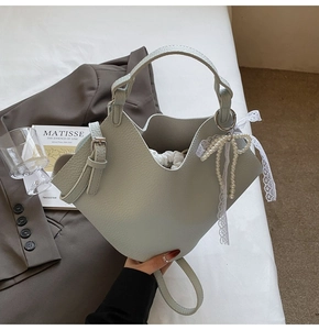 Dettaglio della borsa a secchiello verde menta con texture litchi e fiocco di perle