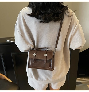 Vue arrière d'un mannequin portant un petit sac carré vintage marron foncé en similicuir