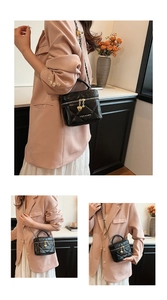 Détail du mini sac matelassé noir avec chaîne dorée et breloque cœur au zip