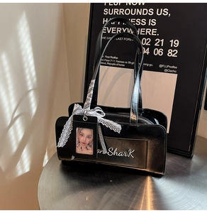 Dettaglio borsa a spalla nera lucida con stampa Shark e porta tessere in pizzo elegante