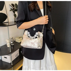 Detail of plum blossom embroidery on satin hobo bag with ice-crack pattern beaded handle