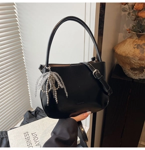 Detail der schwarzen Leder-Beuteltasche mit eleganten silbernen Perlenquasten