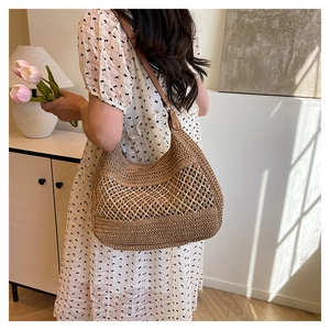 Dettaglio borsa hobo intrecciata a mano con griglia beige e tracolla in finta pelle marrone