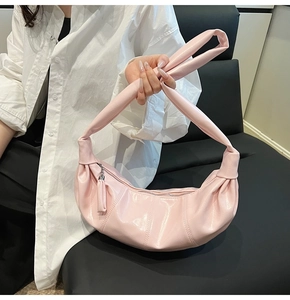 Detailed view of pink pleated PU leather dumpling bag with knotted shoulder strap