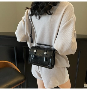 Sac bandoulière en cuir brillant noir avec poignée unique et boucles argentées