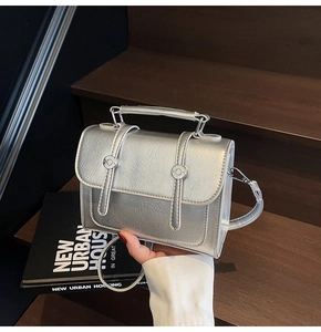 Vue détaillée du sac argenté métallisé avec texture plissée et sangles à boucles