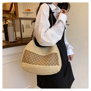 Detail of hand-woven straw shoulder bag with hollow mesh design and leather strap