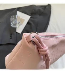 Vue détaillée du sac cabas en cuir rose gaufré avec fermeture éclair et détails argentés