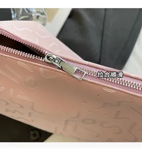 Gros plan sur la fermeture éclair en métal argenté du sac cabas rose gaufré