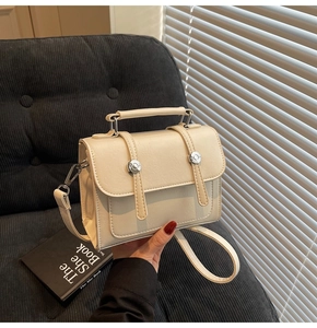 Détail du sac bandoulière vintage crème avec boucle argentée et poignée supérieure