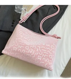 Détail du sac en similicuir rose avec texture ondulée en relief et lanières nouées