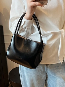 Minimalistische schwarze Leder-Eimertasche mit Logo in einem lässigen Lifestyle-Outfit