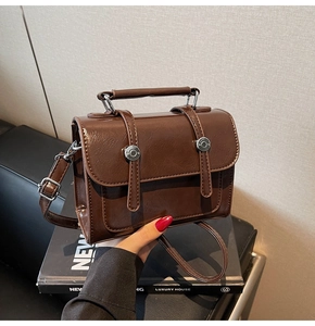 Détail du sac à main vintage en similicuir marron foncé avec fermoir argenté et anse