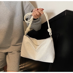 Détail du sac cabas blanc avec gaufrage géométrique et bandoulière à nœuds élégante