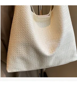 Close-up of white woven leather texture on a large hobo tote bag with shoulder strap