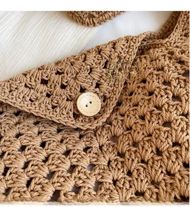 Detailed close-up of the woven texture and wooden button closure on the brown bag