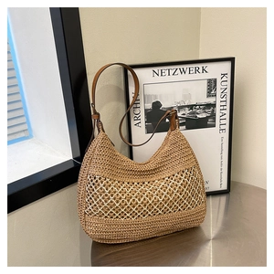 Detail showing the brown woven straw texture and mesh pattern of the beach hobo bag