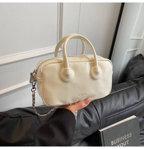 Detail of off-white bowling bag with CLEAROK lettering and silver chain strap