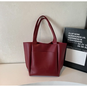 Macro detail of wine red tote bag with smooth matte leather texture and front pocket