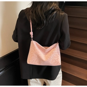 Sac cabas rose à motifs abstraits blancs avec bandoulière nouée porté par un modèle