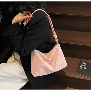 Détail du sac fourre-tout rose avec texture 3D gaufrée et bandoulière en cuir nouée