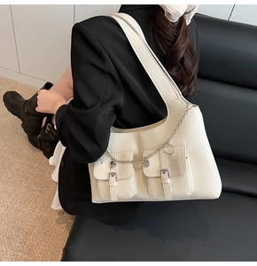 Detail of white multi-pocket tote bag with silver chain and functional card holder