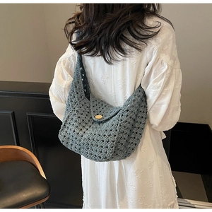 Detailed close-up of blue-grey hollow knit pattern with a wooden button closure