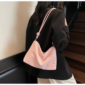 Détail du sac bandoulière rose avec motifs géométriques en relief et nœuds décoratifs